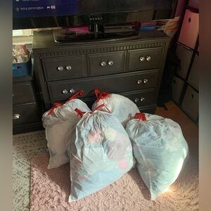 4 bags of clothes, including dresses, jeans, skirts, pants, shorts, and shirts.